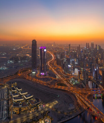 Aerial view of Dubai Downtown skyline and highway, United Arab Emirates or UAE. Financial district and business area in smart urban city. Skyscraper and high-rise buildings at night.