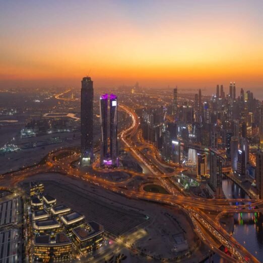 Aerial view of Dubai Downtown skyline and highway, United Arab Emirates or UAE. Financial district and business area in smart urban city. Skyscraper and high-rise buildings at night.