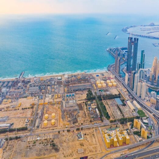Aerial view of petrochemical oil refinery and sea in industrial engineering and energy concept in Dubai, urban city, UAE. Oil and gas tanks pipelines in industry. Modern metal factory. Power plant.